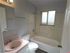 Bright and inviting bathroom featuring a modern sink, elegant bathtub, and frosted glass window for natural light.