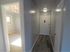 Bright and welcoming apartment hallway with sleek wood flooring and natural light flowing through adjacent room.