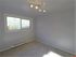 Bright, airy room with sleek modern lighting and large window, offering an abundance of natural light.