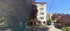 Charming four-story apartment building with welcoming entrance, surrounded by lush greenery and vibrant urban setting.