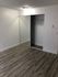 Modern bedroom with sleek mirrored closet doors and elegant wood flooring, offering ample storage space and a clean, contemporary aesthetic.