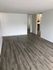 Bright and spacious living area with modern wood flooring and open layout, perfect for stylish living.