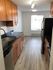 Modern kitchen with sleek wooden cabinets, stainless steel appliances, and elegant lighting, offering a bright and inviting atmosphere.