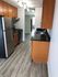 Modern kitchen with sleek stainless steel appliances, elegant wood cabinetry, and stylish track lighting on a beautiful wood floor.