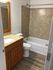 Elegant bathroom showcasing a modern granite countertop, wooden cabinetry, and sleek bathtub for a luxurious touch.