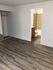 Inviting apartment with sleek hardwood floors, a cozy mirrored closet, and an adjacent modern bathroom with stylish tile.