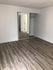 Bright and spacious bedroom with elegant hardwood floors and a sleek mirrored closet door.