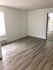 Bright and inviting room with elegant wood flooring and a large mirrored closet, perfect for a cozy bedroom.