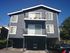 Charming three-story residential building with balconies, located in a peaceful suburban neighborhood.