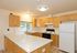 Bright and inviting kitchen with modern appliances, sleek countertops, and ample wooden cabinetry.