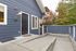Charming exterior of modern apartment with inviting front door and stylish navy blue siding, surrounded by lush trees.