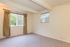 Bright and spacious empty room with beige walls, large window, and elegant curtains, perfect for customization.