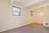 Bright and inviting room with soft beige walls, plush carpet, and ample natural light from large windows, perfect for a cozy living space.
