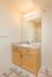 Bright and inviting bathroom featuring a sleek vanity with ample storage, a large mirror, and modern lighting fixtures.