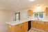 Bright and inviting kitchen with natural wood cabinets, modern countertops, and ample natural light.