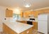 Bright, modern kitchen with elegant wooden cabinetry, sleek countertops, and ample natural light, perfect for culinary enthusiasts.