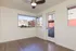 Bright and airy room with hardwood floors, modern ceiling fan, and large windows offering scenic views.