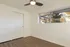 Bright and airy room featuring sleek wooden floors, a modern ceiling fan, and large windows showcasing a scenic outdoor view.