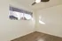 Bright empty room with large window, sleek ceiling fan, and elegant wood flooring, perfect for customization.