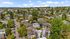 Charming aerial view of a vibrant neighborhood showcasing lush greenery, modern homes, and a network of quaint tree-lined streets.