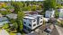 Modern multi-story home with sleek design surrounded by lush greenery in a picturesque neighborhood.