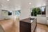 Bright and spacious open-concept living area with modern kitchen island, large windows, and polished wood floors.