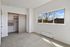 Bright and airy bedroom featuring a spacious closet with modern shelving, large window with scenic views, and plush carpeting.