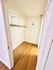 Spacious walk-in closet with elegant wooden flooring and ample shelving, offering a blend of style and functionality.