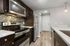 Modern kitchen with sleek stainless steel appliances, stylish tile backsplash, and elegant dark wood cabinetry.