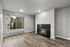 Modern living room with elegant hardwood floors, cozy fireplace, and large window offering natural light and scenic views.
