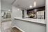 Chic modern kitchen with stainless steel appliances, large window, and elegant pendant lighting.