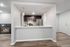 Modern kitchen area with sleek stainless steel appliances, elegant pendant lighting, and a cozy fireplace in the open layout.