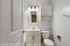 Modern bathroom with sleek white vanity, large mirror, and elegant lighting.