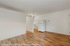 Bright, open living space with elegant hardwood floors and a sleek white refrigerator, perfect for modern living.