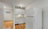 Inviting kitchen with sleek white cabinetry, modern appliances, and warm wood flooring for a cozy ambiance.