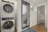 Chic apartment hallway featuring a modern stacked washer and dryer, with adjacent access to a sleek bathroom and stairway.