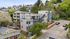 Charming urban apartment building nestled in a lush, green residential area, featuring modern architecture and a welcoming neighborhood ambiance.