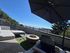 Inviting rooftop terrace with a modern outdoor lounge, fire pit, and scenic city view under a clear blue sky.
