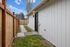 Charming exterior walkway with a modern wooden fence and pristine siding, offering a welcoming entrance to the home.