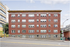 Charming brick apartment building with classic architecture, featuring multiple windows and a prime urban location.