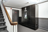 Modern apartment lobby featuring a sophisticated package concierge system beside a stylish staircase.