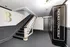 Modern apartment lobby with elegant staircase, bold letter B, and convenient package concierge service.