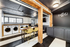 Chic communal space featuring a modern laundry area with washing machines and a stylish coffee bar, perfect for convenience and relaxation.