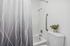 Modern bathroom featuring an elegant shower curtain, sleek fixtures, and a touch of greenery for a refreshing ambiance.