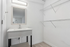 Bright bathroom with modern vanity and ample shelving, perfect for stylish storage solutions.