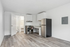 Modern apartment with sleek kitchen, light wood floors, stainless steel appliances, and open layout for flexible living.