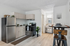 Modern kitchen with stainless steel appliances, sleek cabinetry, and a cozy dining area in a stylish apartment.