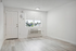 Bright, minimalist room with large window, modern floor, and efficient air conditioning unit.