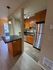 Modern kitchen view showcasing stainless steel appliances, sleek countertops, and warm wooden cabinetry.