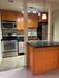Modern kitchen with sleek stainless steel appliances, warm wooden cabinets, and elegant track lighting.